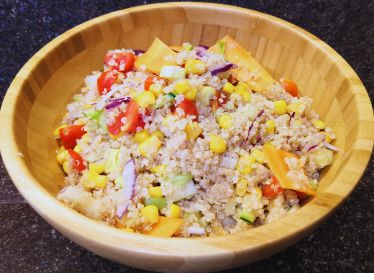 Insalata di quinoa estiva con verdure fresche in ciotola, ricetta light e colorata